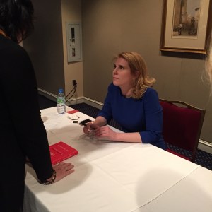 Amy Wilkinson, author of the Creator's Code,  listens carefully to people as they stop by to get their books autographed.  